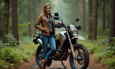 Jeune femme souriante avec moto tout-terrain en forêt