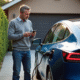 Homme d'âge moyen avec voiture électrique en charge