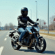 Jeune motard en équipement sur petite moto en parking