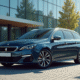 Peugeot 308 station wagon devant un bâtiment moderne ensoleillé