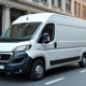 Véhicule Peugeot Boxer blanc en ville en journée